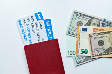 Passport with airline tickets and money with us dollars and euros on a white background with top view