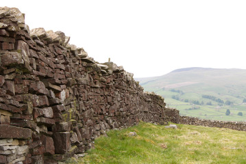 dry stacked stone wall with the hills of the  Yorkshire Dales United Kingdom in the background