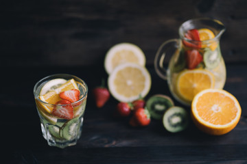 Lemonade of citrus, kiwi and strawberry. Tasty summer refreshing drink, infused water with fruits and berries. Homemade vitamin beverage
