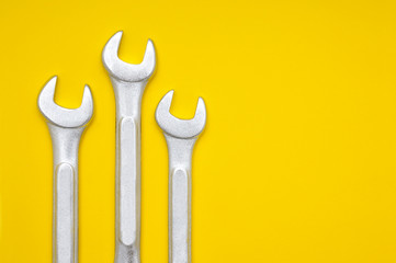 Three wrenches on a yellow background