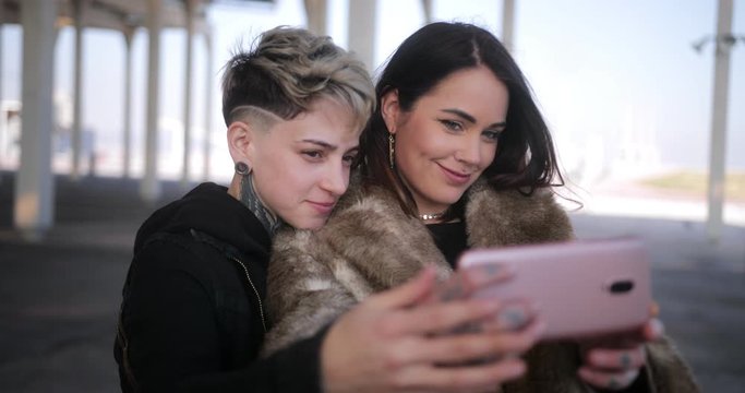 Lesbian couple embracing each other and taking a selfie