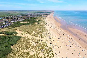 beautiful sandy beach aerial view, with sunbathers enjoying the summer beach at Camber Sands, England