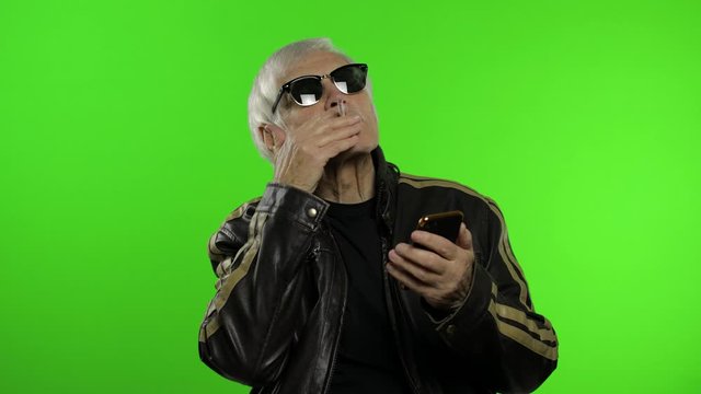 Elderly stylish caucasian grandfather man using smartphone for online shopping