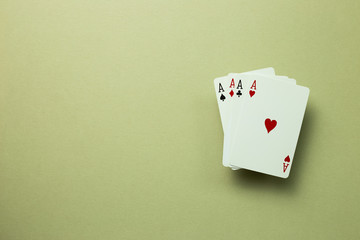 Four aces cards on khaki green background. top view, copy space