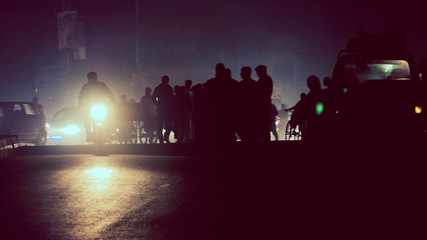 Silhouette of crowds and motorcycle headlights