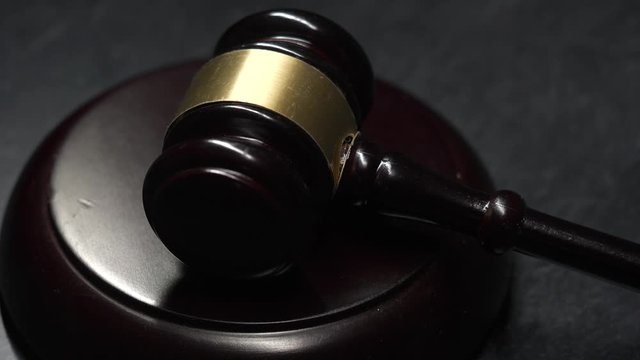 Dramatic Closeup of light illuminating a judge gavel and a hammer while it passing over it