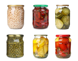 Set of jars with pickled vegetables on white background