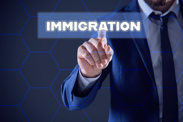 Businessman touching icon with word IMMIGRATION on virtual screen against color background, closeup