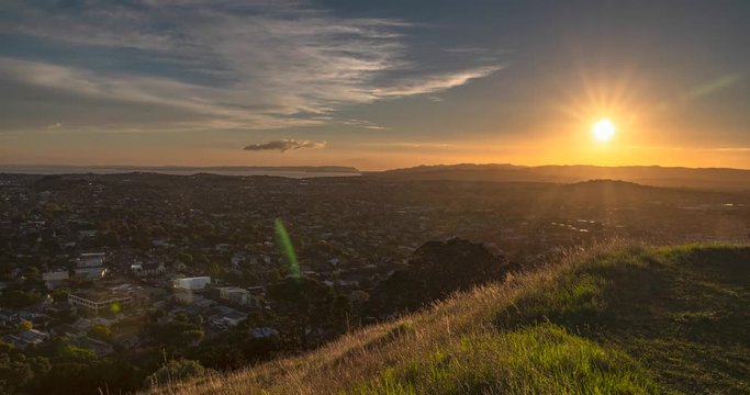 Auckland, New Zealand. Sunset Time lapse on the top of Maungarei/Mount Wellington overlooking the suburbs. Includes 2 versions - 1 stationary, 1 digital zoom out using the full image resolution.