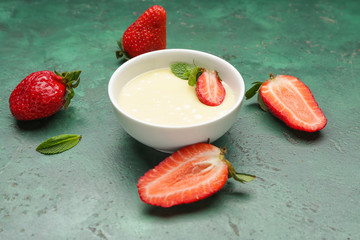 Bowl with tasty strawberry and melted chocolate on color background