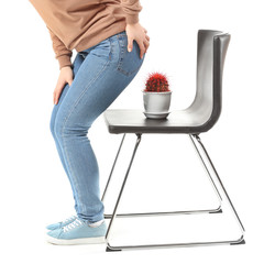 Young woman and chair with cactus on white background. Hemorrhoids concept