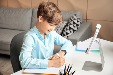 Cute little boy studying at home. Concept of online education