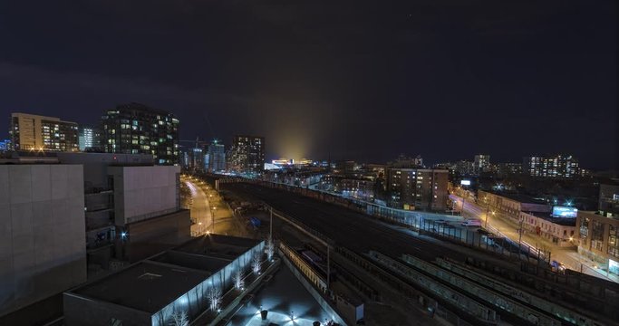 Wide angle night city time-lapse overlooking train tracks just outside downtown Toronto Ontario, Canada , from a high rise building. Lights from BMO Field can be seen in the distance.