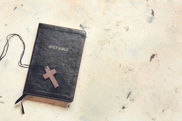 Holy Bible and cross on light background