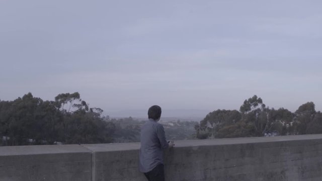 Lonely college boy man looks out into the distance at UCSD depressed