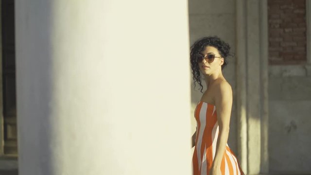 Fashion girl walking behind palace columns