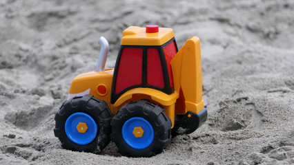 Diggers toys Bucket spade sandcastle on sandy beach with sea wave in  UK