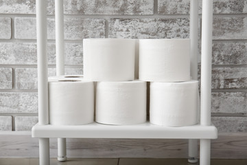 Fototapeta na wymiar Rolls of toilet paper on shelf in restroom