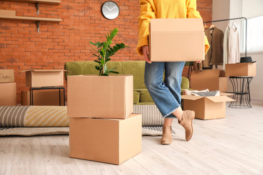 Woman with belongings in cardboard boxes on moving day