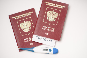 Coronavirus Quarantine and travel concept. Passport with COVID-19 inscription. Coronavirus COVID-19 pandemic. Fever, coronavirus symptoms and travel.