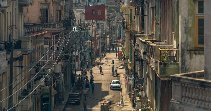 Timelapse from a third floor apartment looking down a busy street during the day in Havana Cuba.