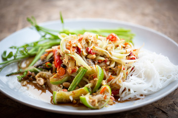 Papaya salad spicy food on white plate. Thai street food.