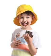 Little boy in dirty clothes eating chocolate cake on white background