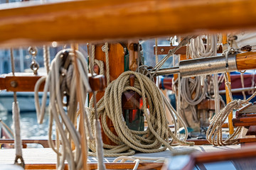 Old wooden sailing ship. Old wooden mast with sails. Sailing ship. Ships' rope on old boat. Wooden block and ropes.