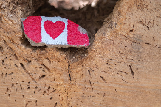 The Canadian flag painted in a small stone with a heart replacing the maple leaf
