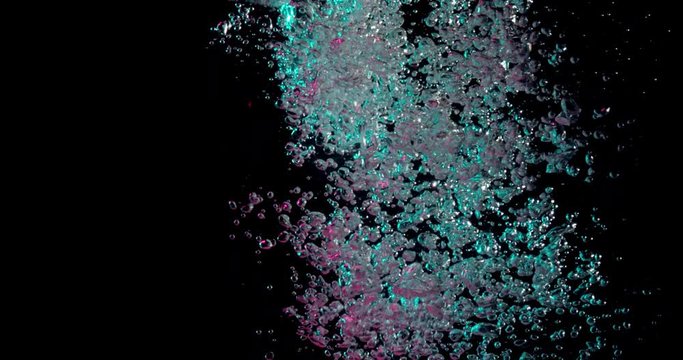 stream of bubbles poring into a dark underwater background and changing from blue to pink.