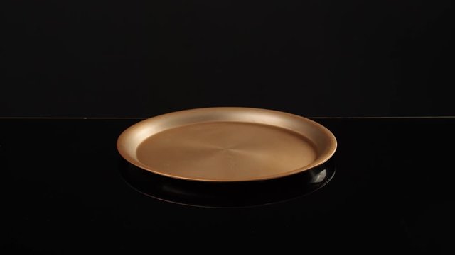 Male waiter opening empty tray on dark background