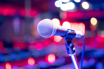 Close up microphone on stage in concert hall restaurant or conference room blurred background