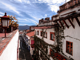 The streets of Taxco de Alarcon, in Guerrero, Mexico, are known for their white houses with red tiles with balconies full of multicolored plants.
