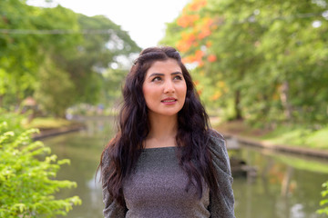Naklejka premium Face of young beautiful Indian woman thinking at the park outdoors