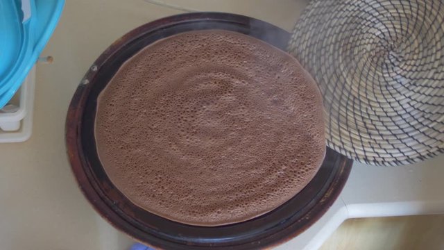 Ethiopian Flatbread also know as injera, cooking process. taking out of the pan.