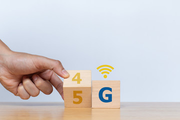 Hand flip wooden cube with the word 4G to 5G with wifi signs on white background. Connect global wireless devices