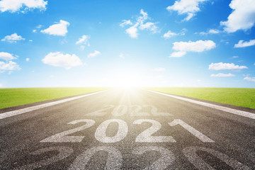 Asphalt road with arrow guideline and 2021 letters painted on the surface. Concept for success in...