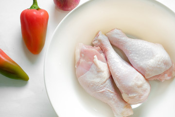raw chicken drumstick in a plate