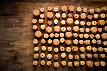 Wine corks of different sizes, standing upright on an old wooden surface. Background for liquor.