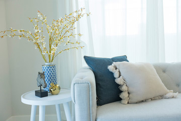 Blue and white pillows on a white sofa, living room interior.