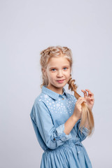  beauty girl braids her blond hair in a braid