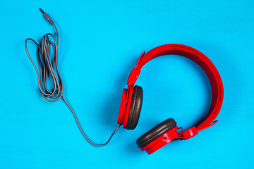 Red headphones on blue background. Music concept