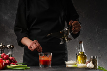 Chef prepares sauce for Italian pasta, on the background of ingredients. European cuisine and recipe book