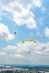 Outdoor city green hill scenery and paragliding
