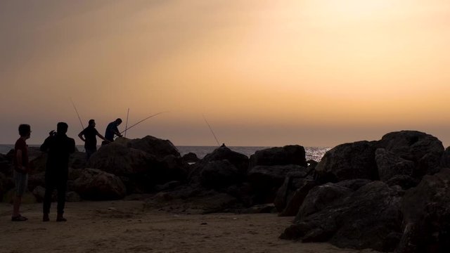 Fishmen on the sunset is catching fish in Israel
