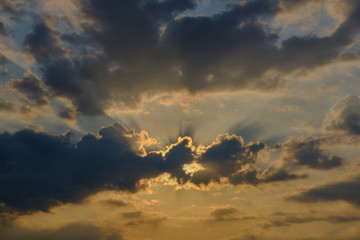 Sunrise on a background of dark gray clouds. Sun, rays of the sun on the background of gray clouds