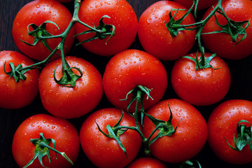 Tomatos on dark wooden background. Healthy food. Dietetic foods. Copy space