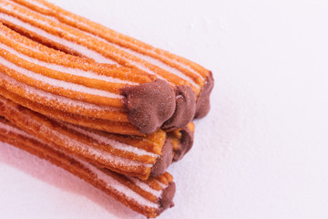 Churros stuffed with chocolate sauce on white background