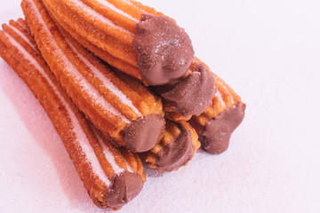Churros stuffed with chocolate sauce on white background