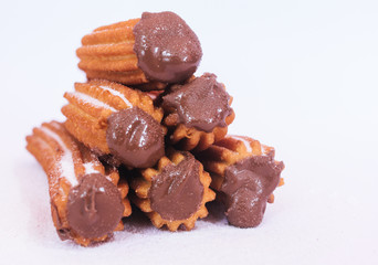 Churros stuffed with chocolate sauce on white background